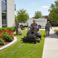 Worker mowing a small lawn with edging